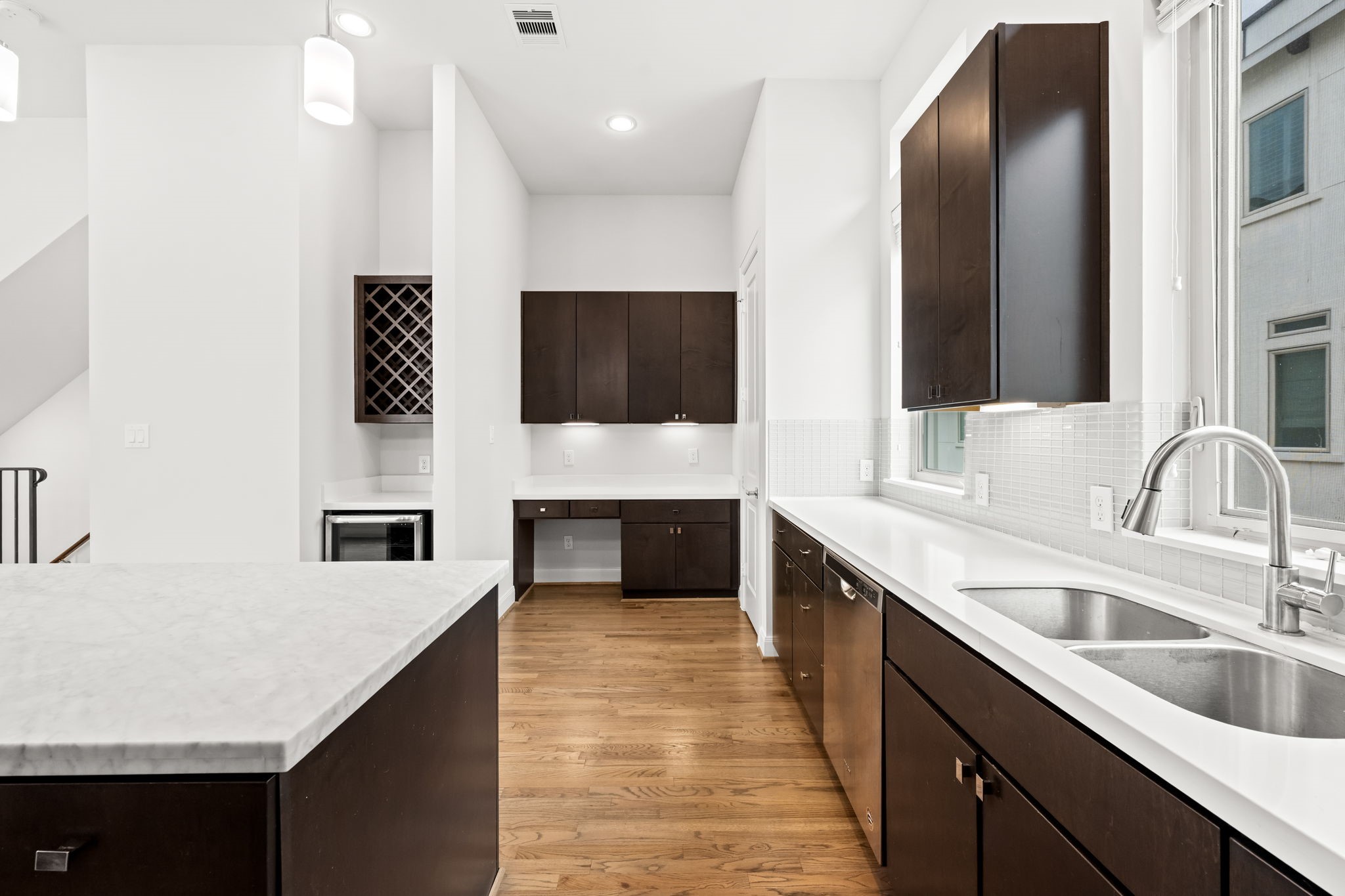 4115 Schuler Street Houston, TX 77007 - Photo 17 of 32 Sleek kitchen features a modern backsplash, built in wine storage and fridge and a dedicated desk area for added function and charm.