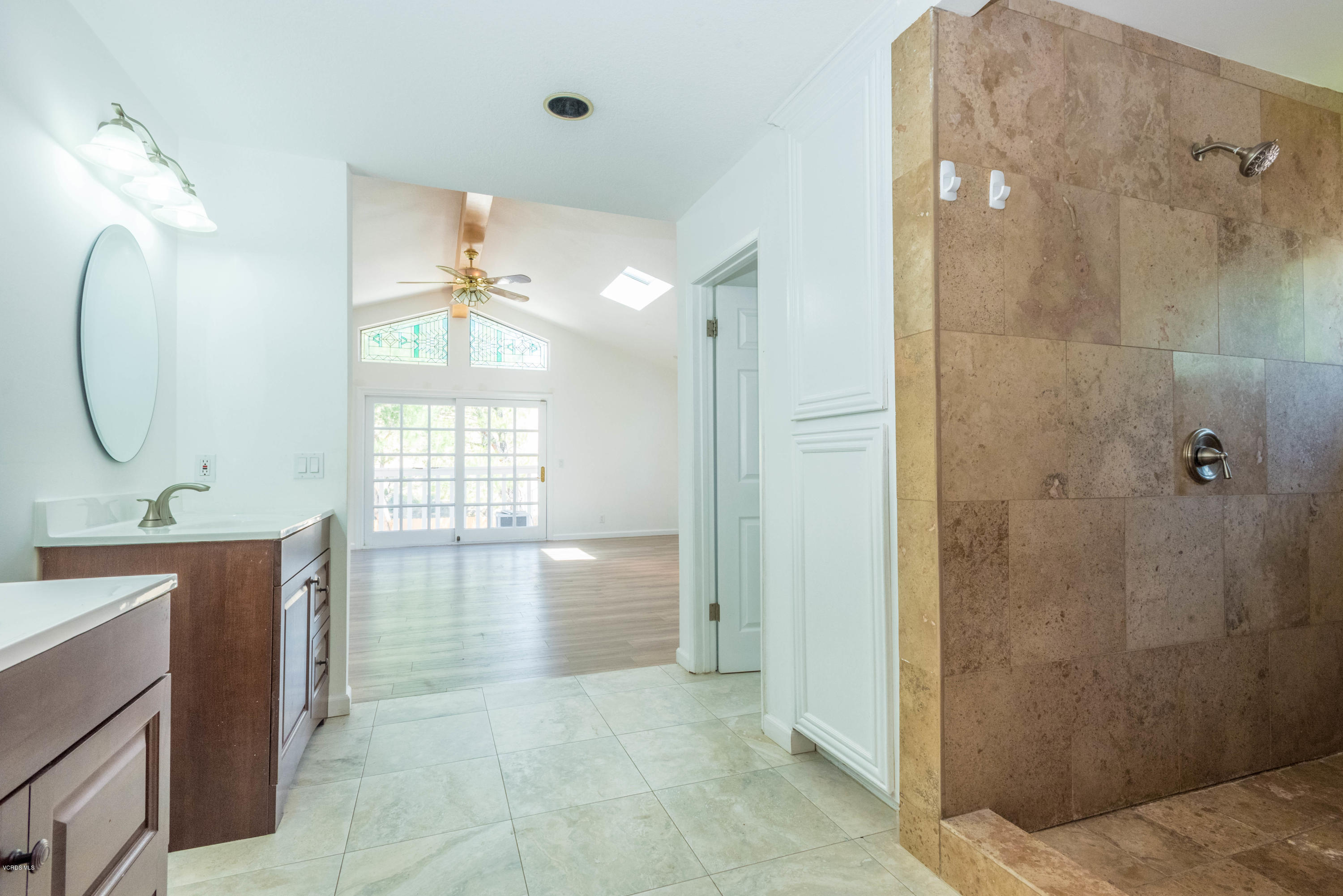 26026 Redbluff Drive Calabasas, CA 91302 - Photo 19 of 23 a spacious bathroom with a mirror a shower and a sink