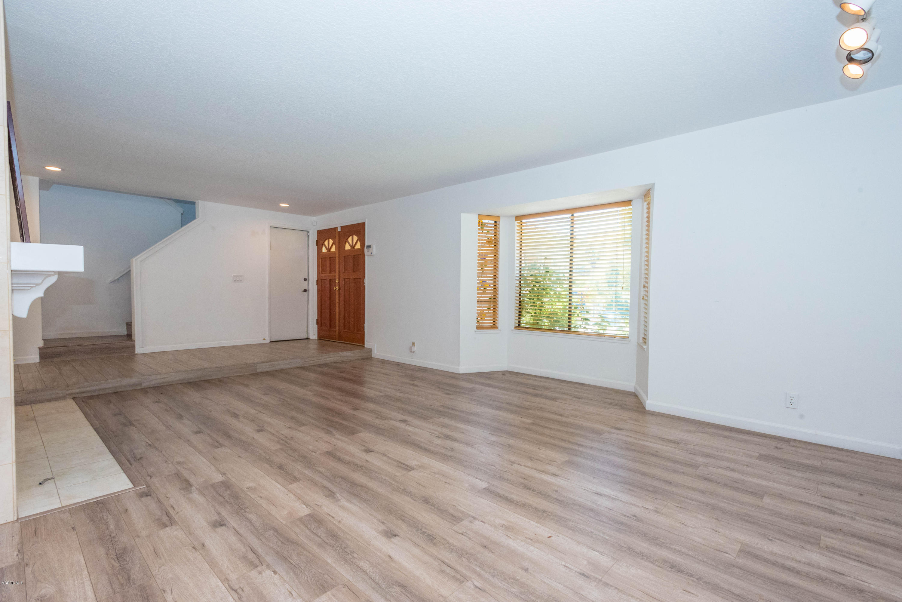 26026 Redbluff Drive Calabasas, CA 91302 - Photo 4 of 23 an empty room with wooden floor and windows