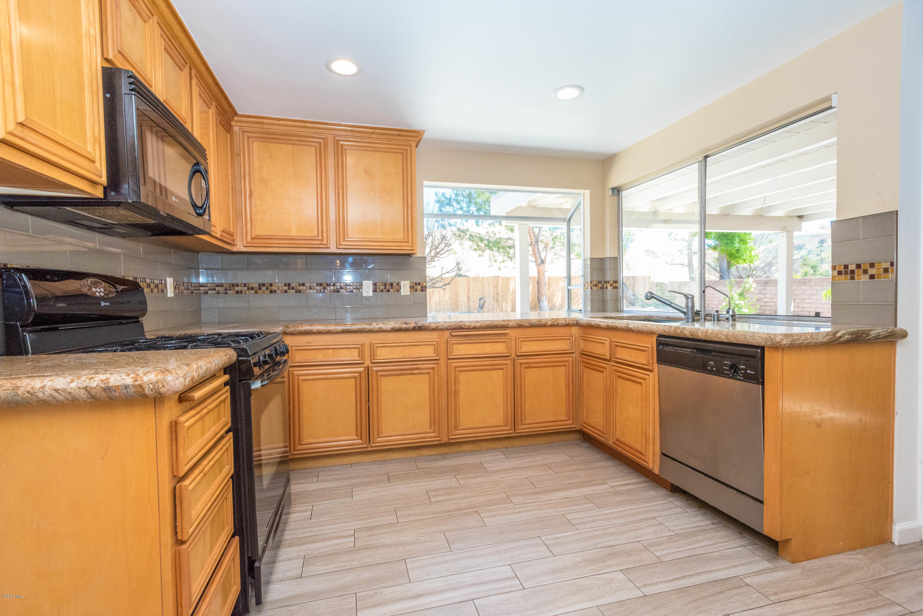 26026 Redbluff Drive Calabasas, CA 91302 - Photo 7 of 23 a kitchen with stainless steel appliances granite countertop wooden cabinets a sink a stove a dining table and chairs