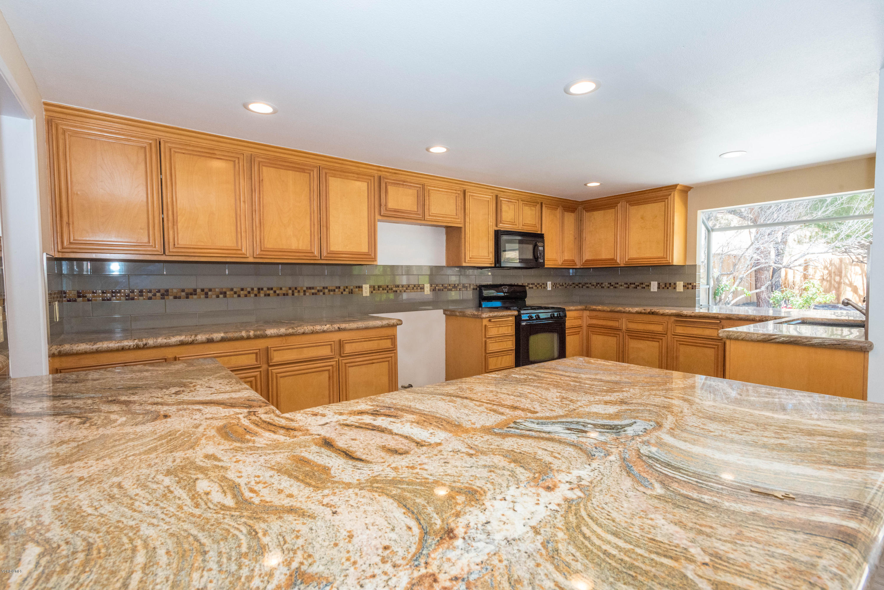 26026 Redbluff Drive Calabasas, CA 91302 - Photo 8 of 23 a large kitchen with kitchen island a stove a sink cabinets and a counter top space