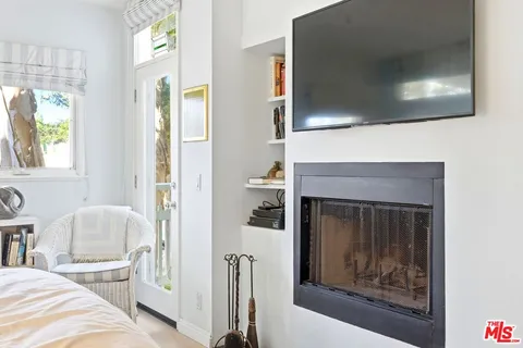 a living room with a fireplace windows and a flat screen tv