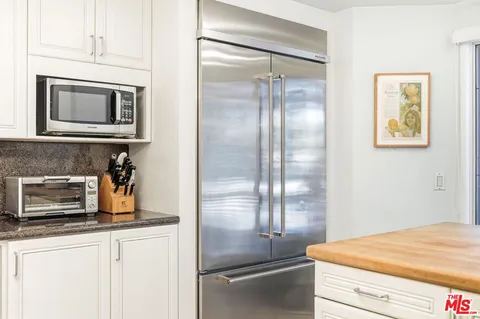 a kitchen with stainless steel appliances granite countertop a refrigerator and a stove top oven