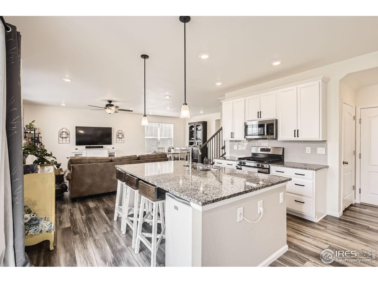 12889 Clearview Street Firestone, CO 80504 - Photo 6 of 38 a kitchen with stainless steel appliances granite countertop a sink dishwasher and a stove with wooden floor