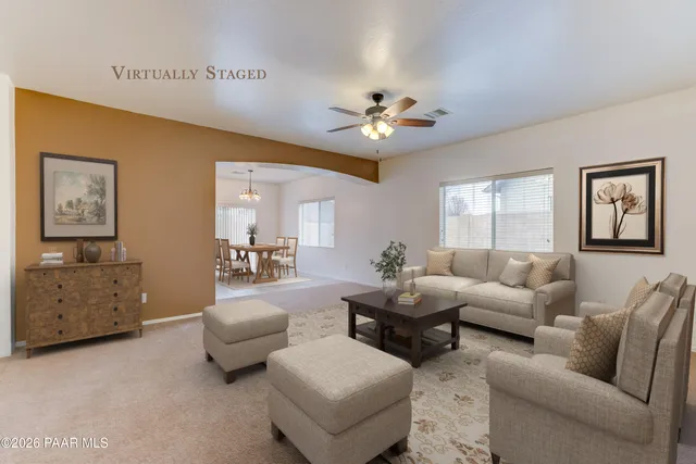 an empty room with windows and ceiling fan