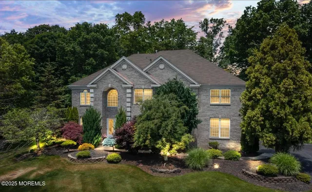 a front view of a house with a yard and trees
