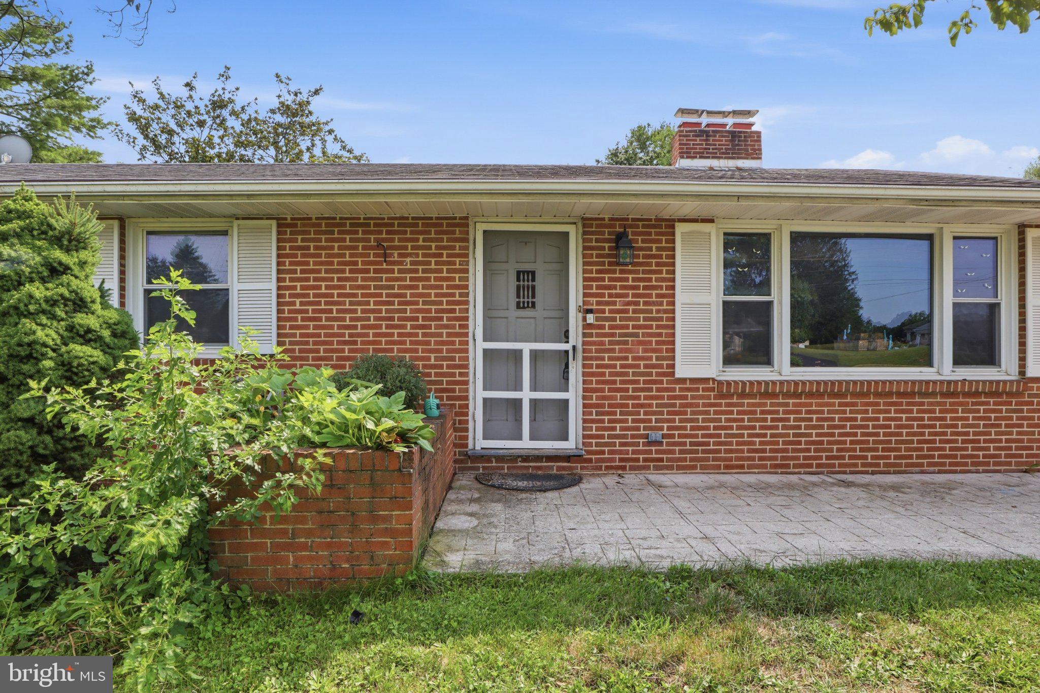 2400 Derry Road York, PA 17408 - Photo 6 of 56 Charming brick facade with lush greenery.