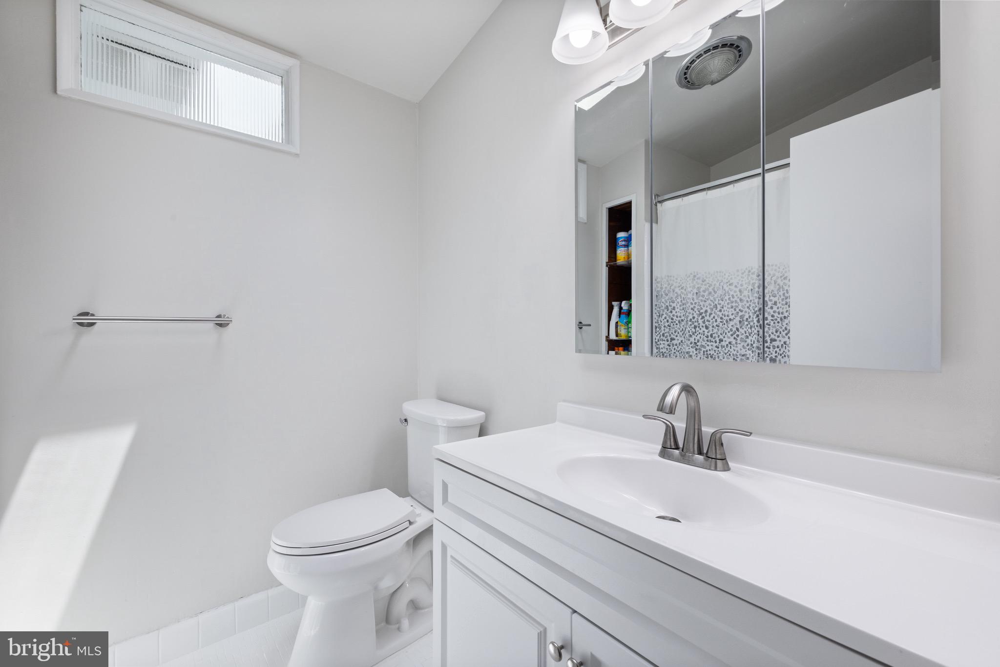 916 Hyde Road Silver Spring, MD 20902 - Photo 14 of 27 a bathroom with a sink a toilet and mirror