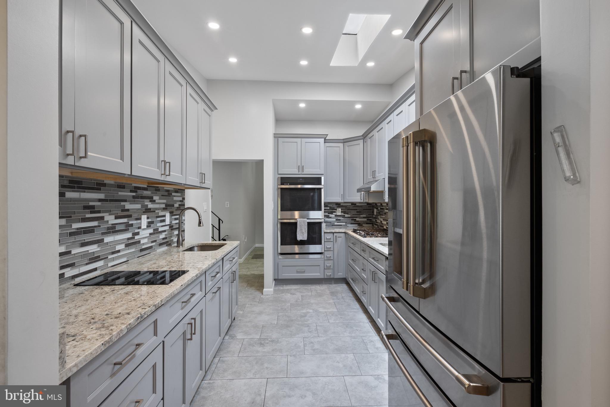 916 Hyde Road Silver Spring, MD 20902 - Photo 4 of 27 a kitchen with granite countertop stainless steel appliances and a refrigerator
