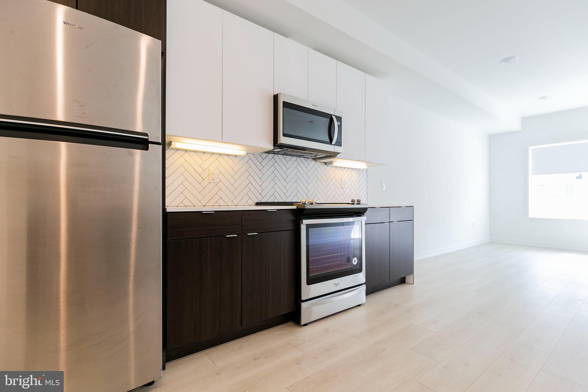 1240 LeCount Street, Unit A Philadelphia, PA 19121 - Photo 2 of 14 a kitchen with stainless steel appliances a refrigerator and a stove