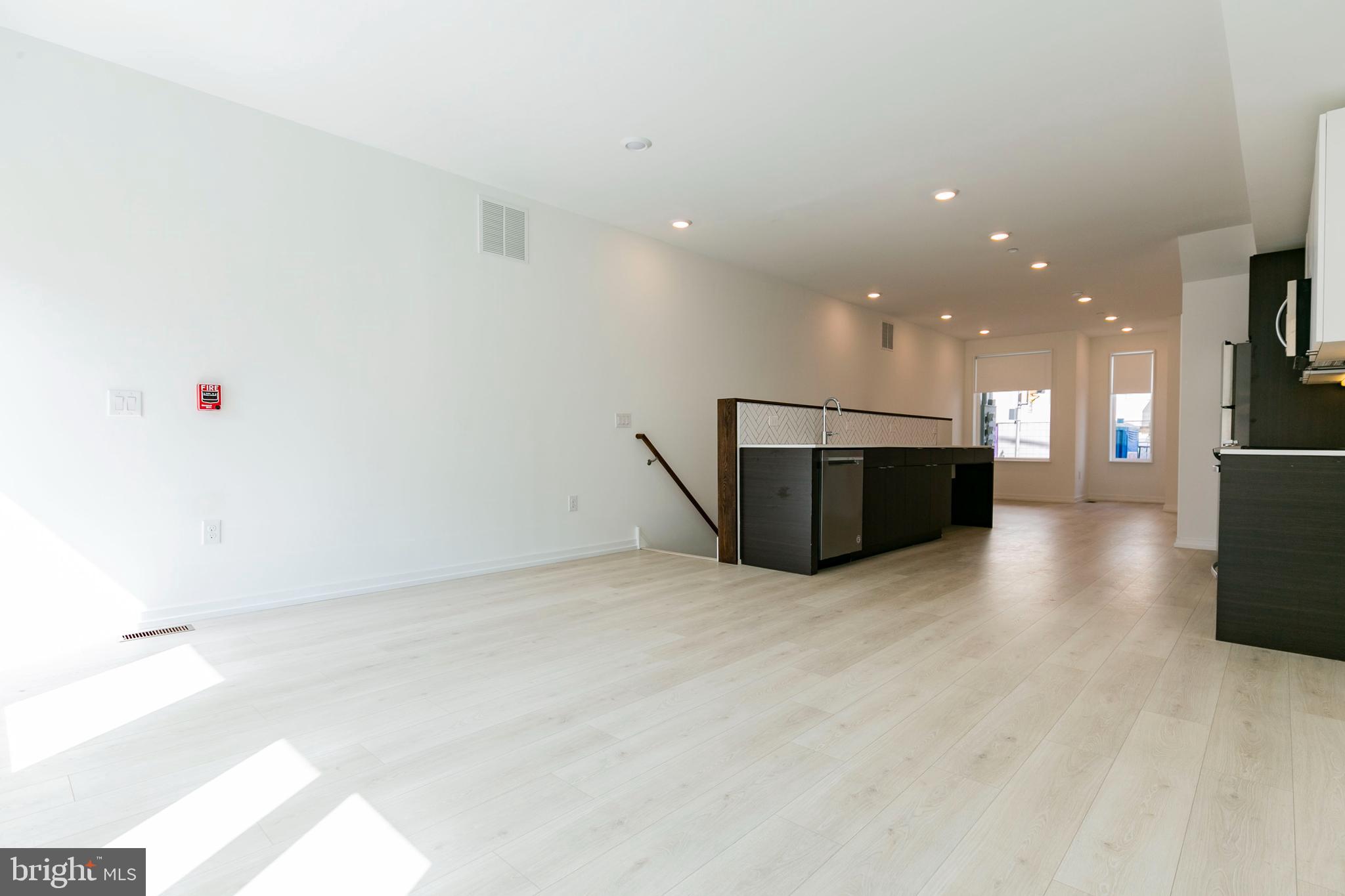 1240 LeCount Street, Unit A Philadelphia, PA 19121 - Photo 5 of 14 an empty room with kitchen microwave and a refrigerator