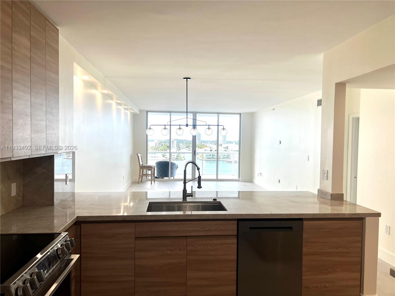 17050 North Bay Road, Unit 1102 Sunny Isles Beach, FL 33160 - Photo 4 of 10 a kitchen with granite countertop a sink and a window
