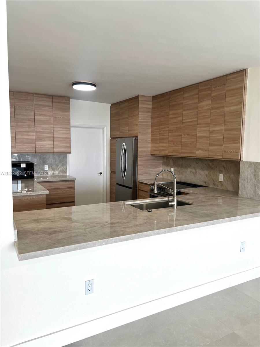 17050 North Bay Road, Unit 1102 Sunny Isles Beach, FL 33160 - Photo 9 of 10 a kitchen with stainless steel appliances granite countertop a sink and a granite counter tops