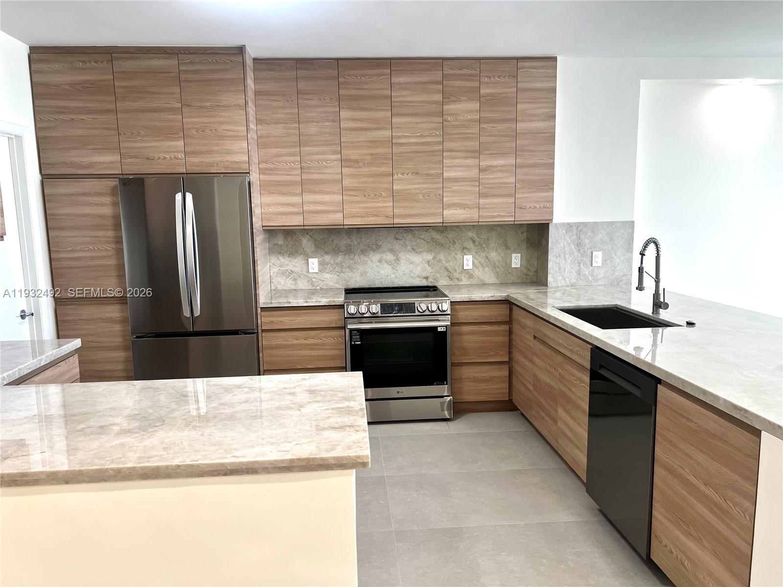 17050 North Bay Road, Unit 1102 Sunny Isles Beach, FL 33160 - Photo 10 of 10 a kitchen with granite countertop stainless steel appliances and sink