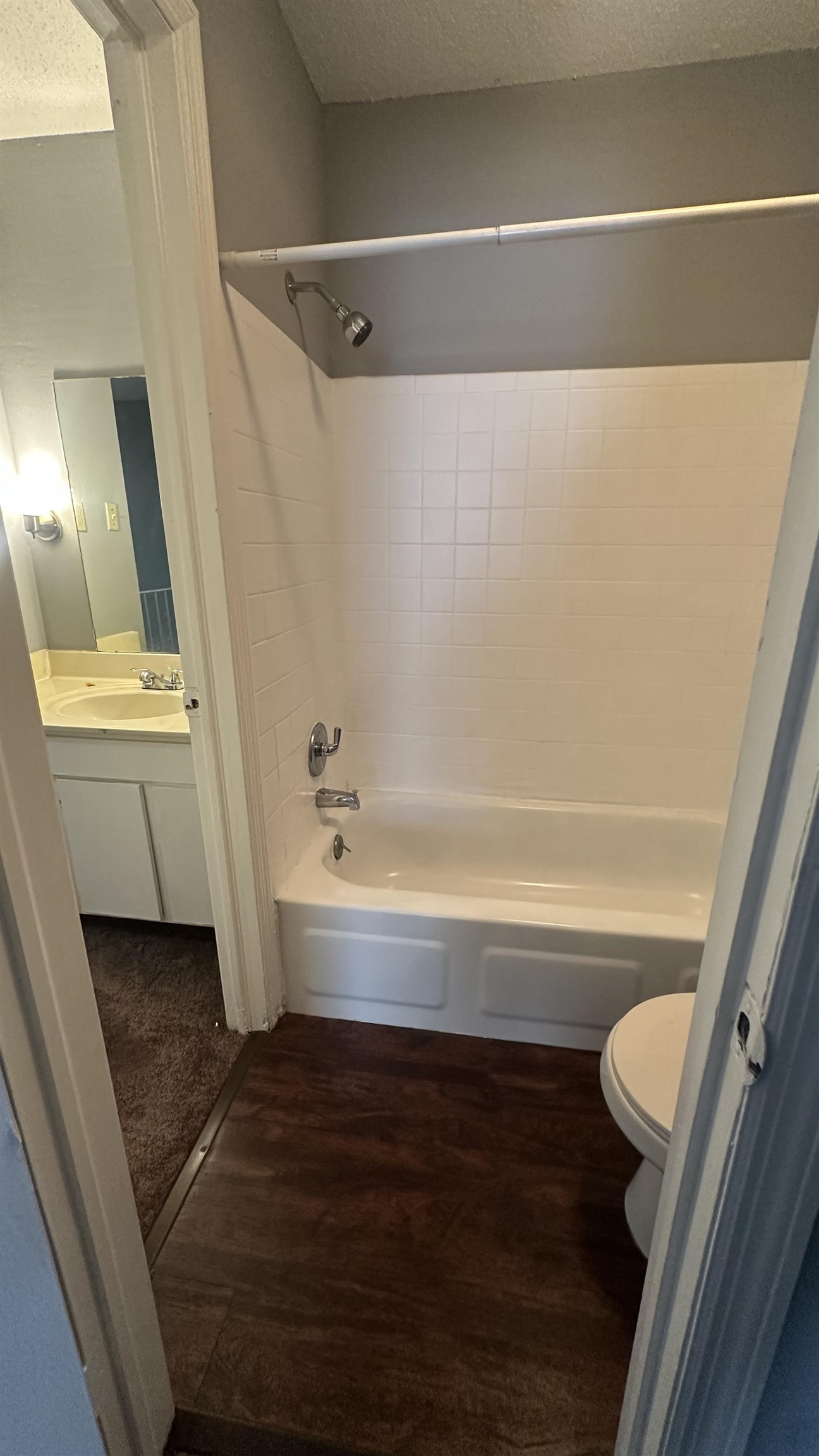 3811 South Mendenhall Road, Unit 3811 Memphis, TN 38115 - Photo 10 of 18 Full bathroom featuring toilet, a textured ceiling, shower / washtub combination, and wood finished floors