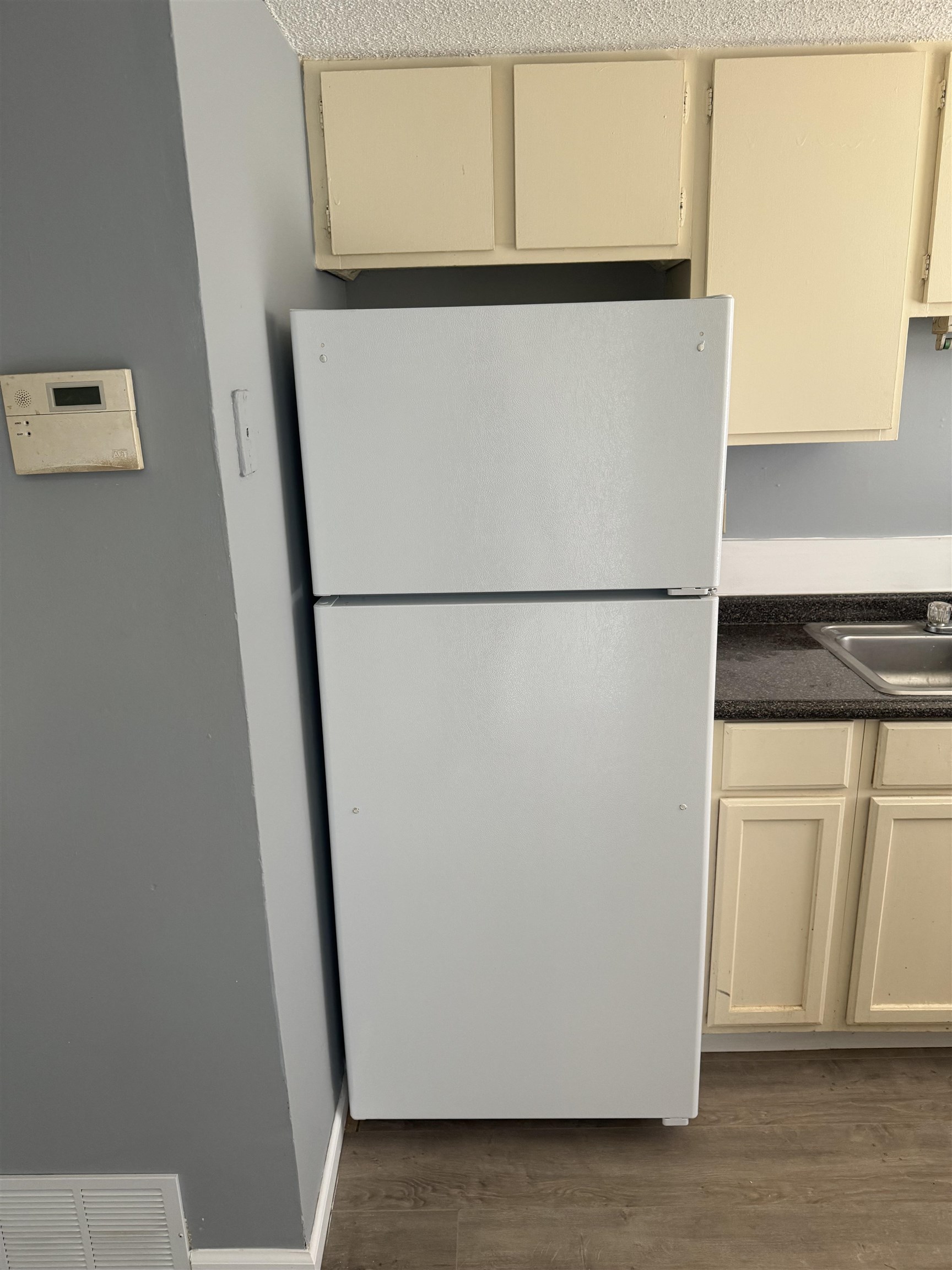 3811 South Mendenhall Road, Unit 3811 Memphis, TN 38115 - Photo 13 of 18 Kitchen with a sink, dark countertops, visible vents, freestanding refrigerator, and cream cabinetry