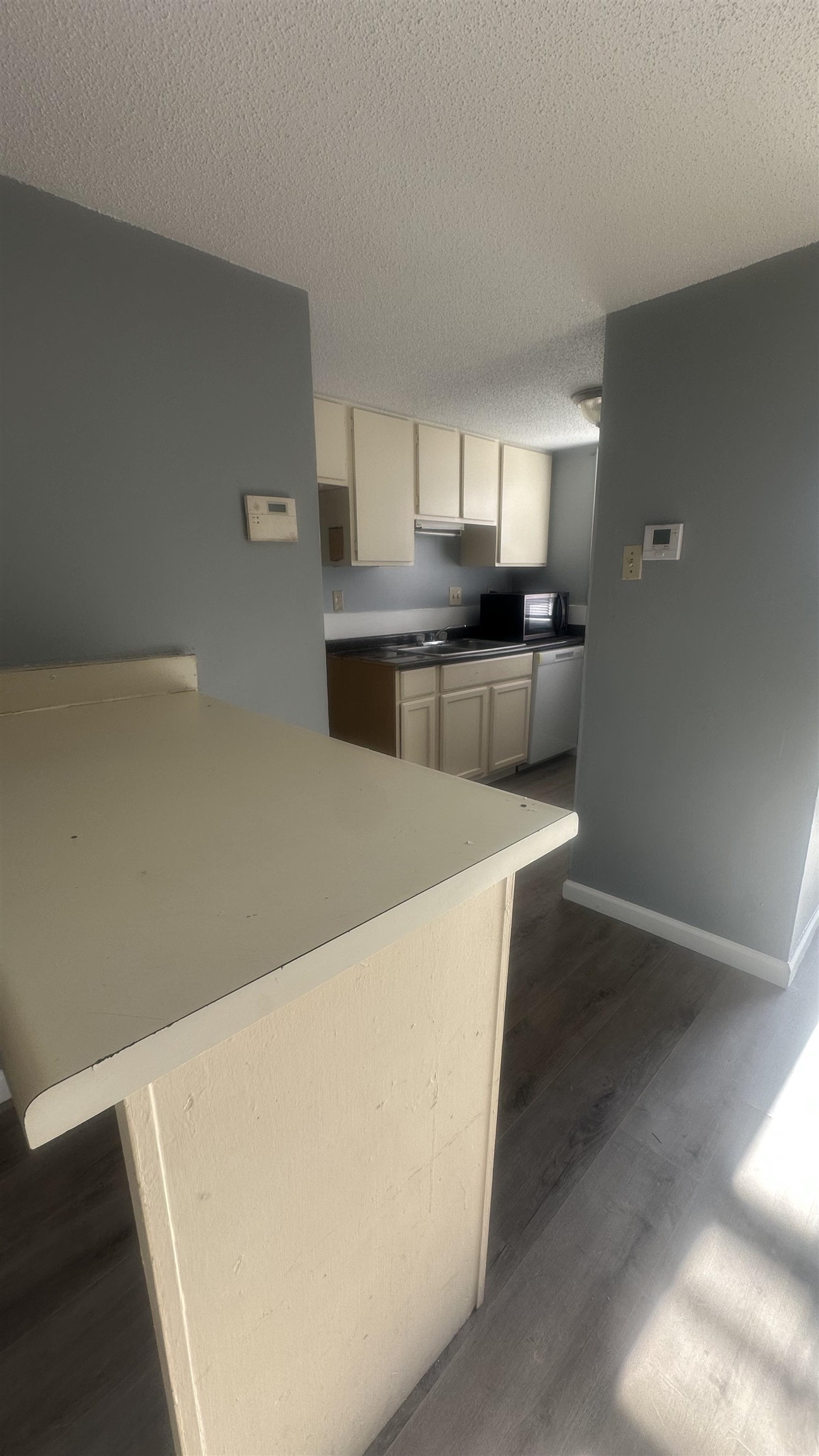 3811 South Mendenhall Road, Unit 3811 Memphis, TN 38115 - Photo 15 of 18 Kitchen with baseboards, dishwasher, a sink, dark wood-style floors, and a textured ceiling