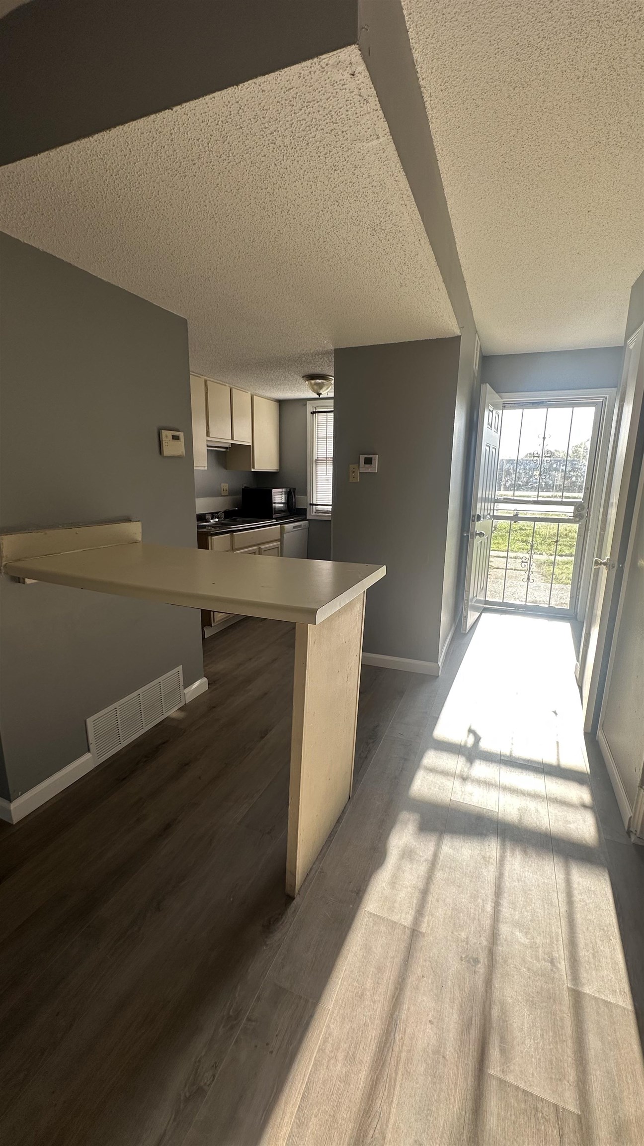 3811 South Mendenhall Road, Unit 3811 Memphis, TN 38115 - Photo 18 of 18 Kitchen featuring baseboards, dark wood-style floors, visible vents, a textured ceiling, and open floor plan