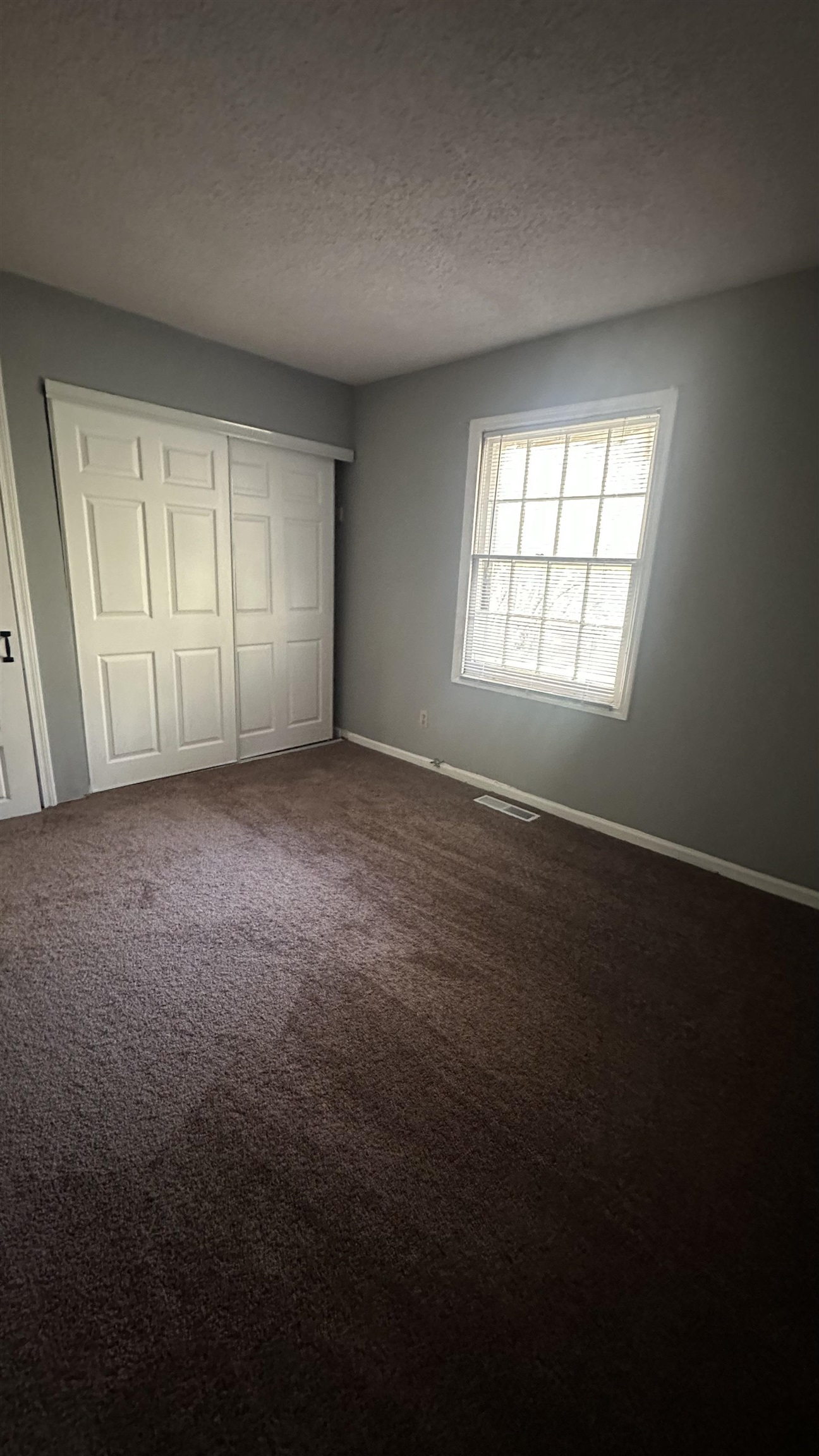 3811 South Mendenhall Road, Unit 3811 Memphis, TN 38115 - Photo 9 of 18 Unfurnished bedroom with a closet, dark colored carpet, baseboards, visible vents, and a textured ceiling