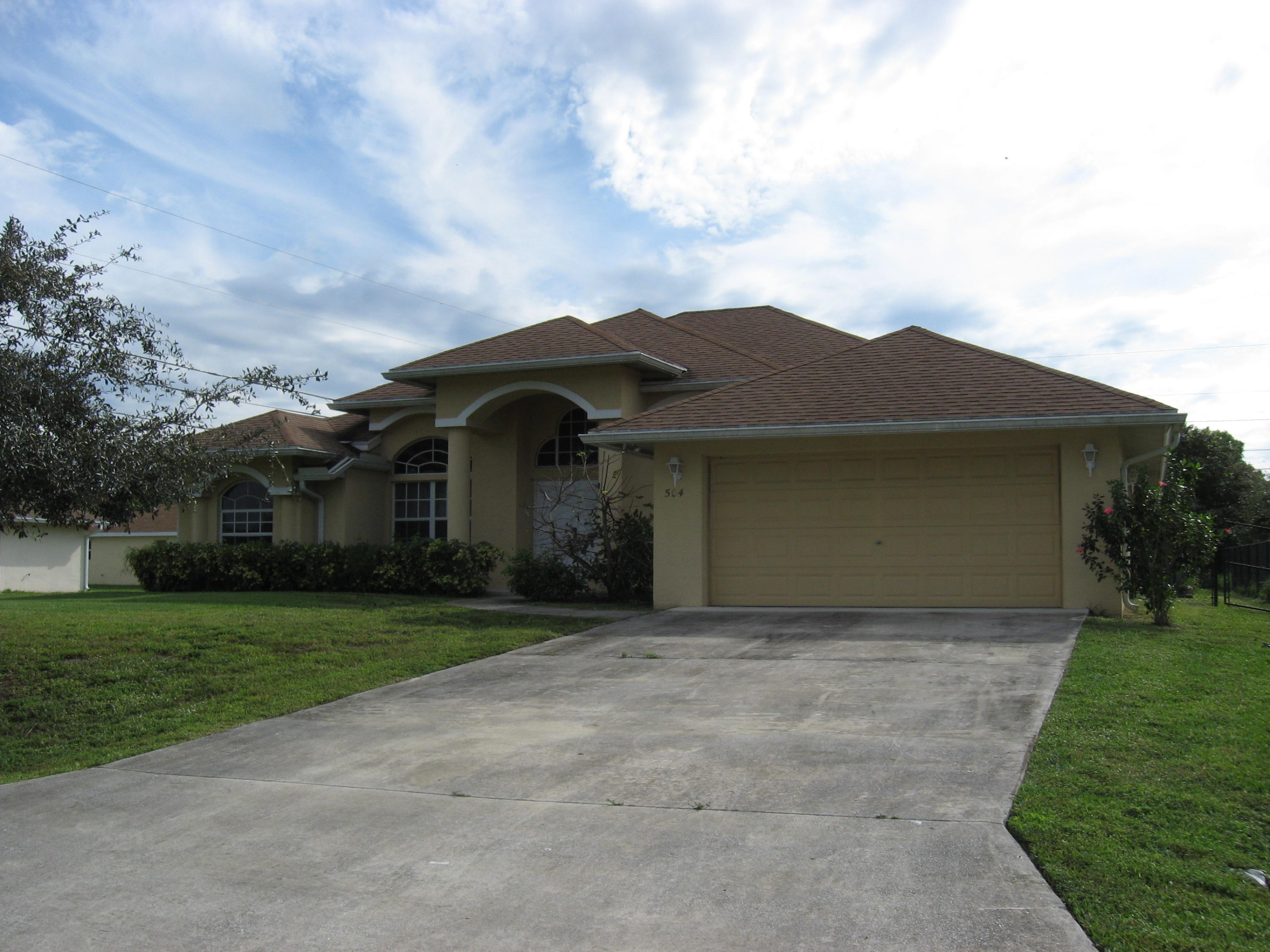 504 Southwest Undallo Road Port St. Lucie, FL 34953 - Photo 1 of 23 a front view of a house with a garden