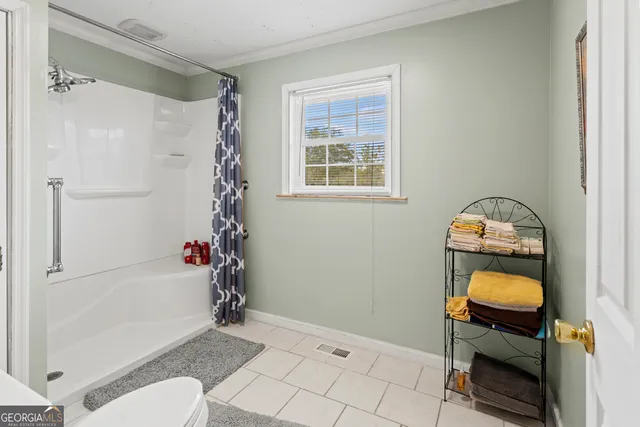 a spacious bathroom with a double vanity sink a mirror and a shower