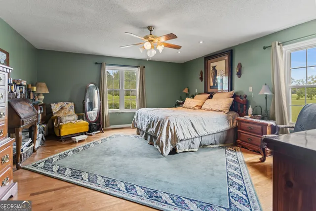 a spacious bedroom with a bed a table and chair