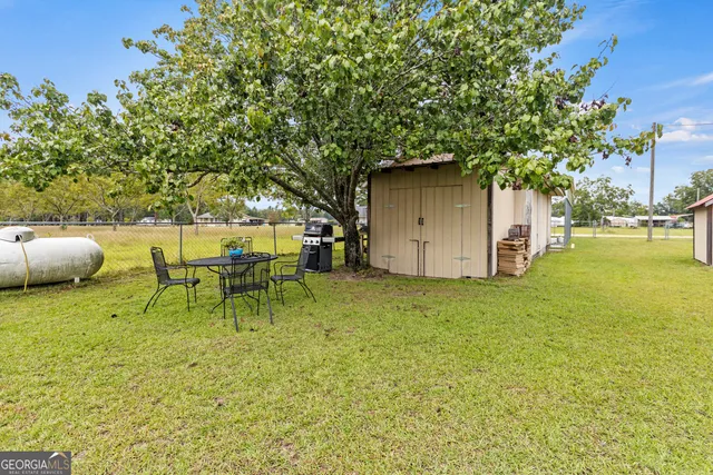 a backyard of a house with table and chairs