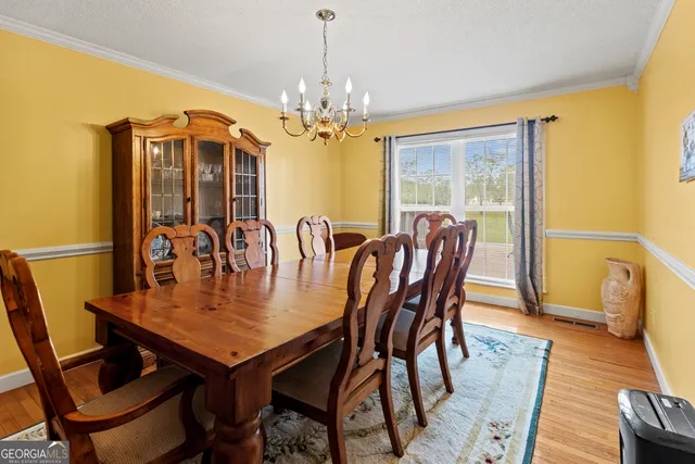 a view of a dining room with furniture wooden floor and chandelier