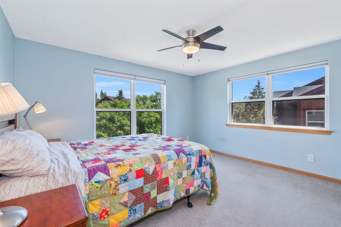 2981 Abbey Road Steamboat Springs, CO 80487 - Photo 24 of 27 a bedroom with a bed a window and a chandelier