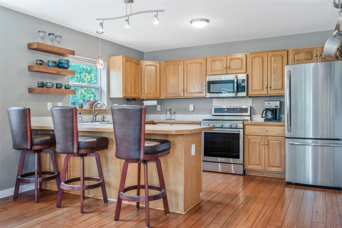 2981 Abbey Road Steamboat Springs, CO 80487 - Photo 7 of 27 a kitchen with stainless steel appliances a stove top oven a refrigerator a sink and a dining table with chairs