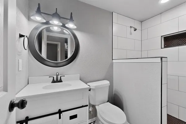 a bathroom with a sink mirror and toilet