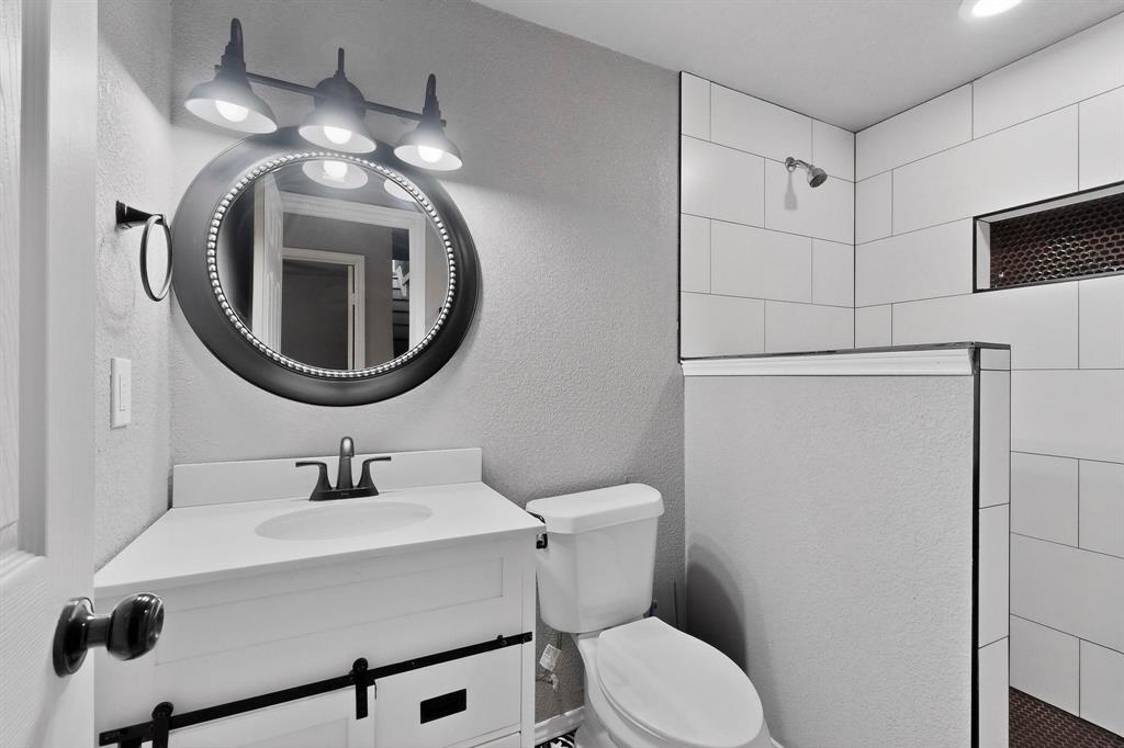 400 South Oak Street Ranger, TX 76470 - Photo 11 of 38 a bathroom with a sink mirror and toilet