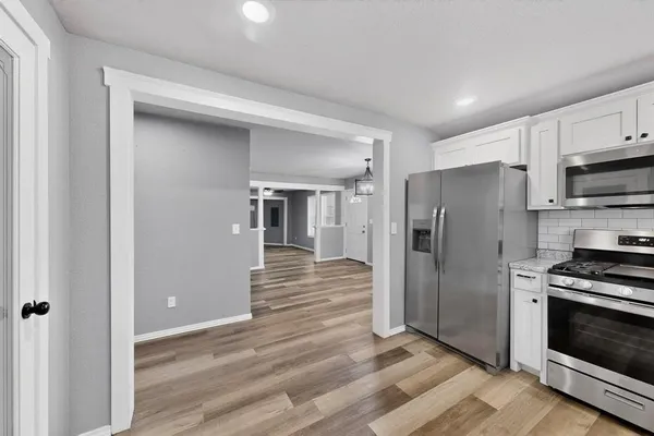 a kitchen with stainless steel appliances a refrigerator and a stove top oven