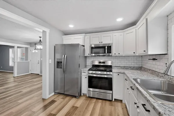 a kitchen with stainless steel appliances a stove a sink a refrigerator and cabinets