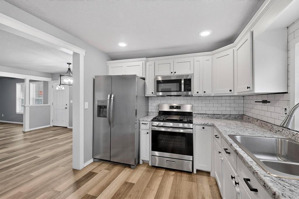 400 South Oak Street Ranger, TX 76470 - Photo 20 of 38 a kitchen with stainless steel appliances a stove a sink a refrigerator and cabinets