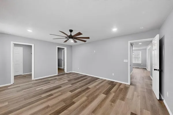 a view of a livingroom with a ceiling fan & entryway