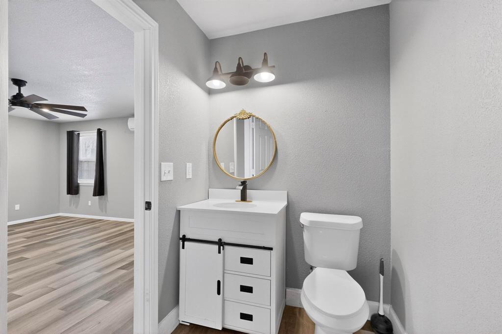 400 South Oak Street Ranger, TX 76470 - Photo 24 of 38 a bathroom with a toilet a sink and a mirror