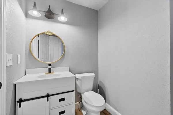 a bathroom with a toilet a sink and mirror