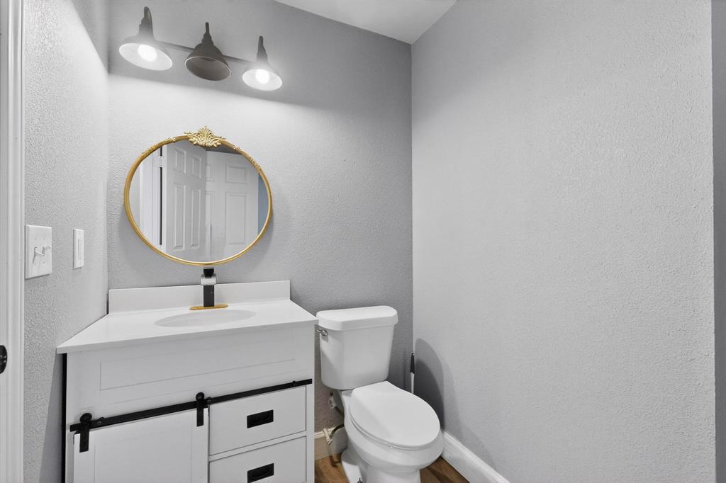 400 South Oak Street Ranger, TX 76470 - Photo 25 of 38 a bathroom with a toilet a sink and mirror