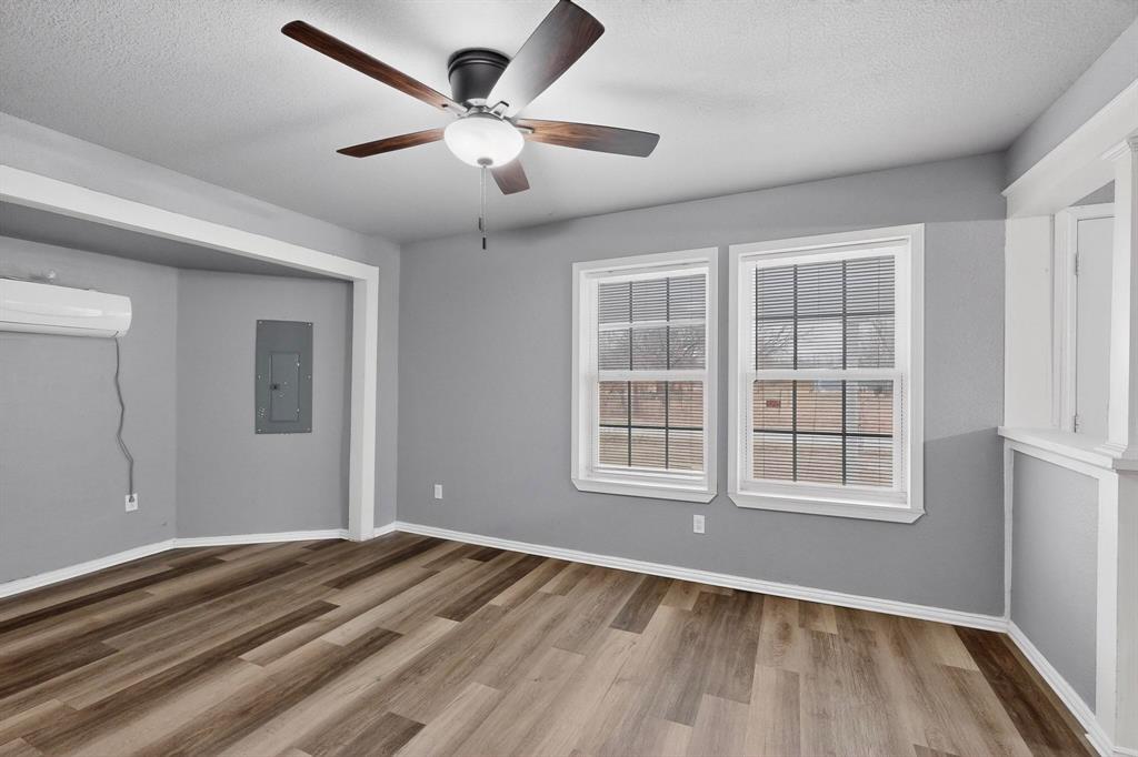 400 South Oak Street Ranger, TX 76470 - Photo 5 of 38 an empty room with wooden floor and windows