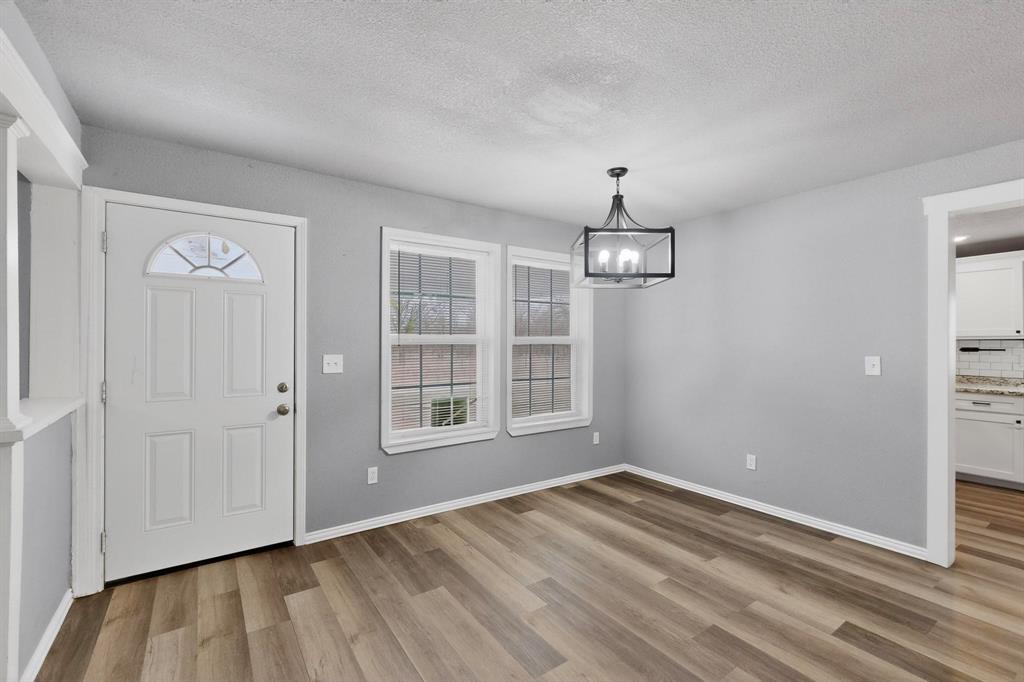 400 South Oak Street Ranger, TX 76470 - Photo 7 of 38 an empty room with wooden floor cabinet and windows