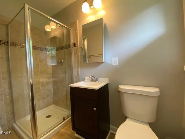 a bathroom with a sink a toilet and shower
