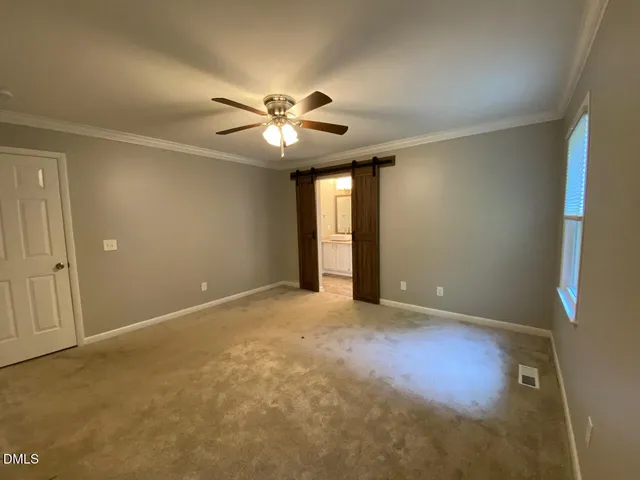 an empty room with a ceiling fan and a window