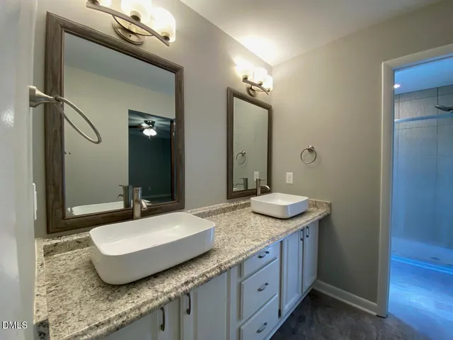 a bathroom with a granite countertop sink and a mirror