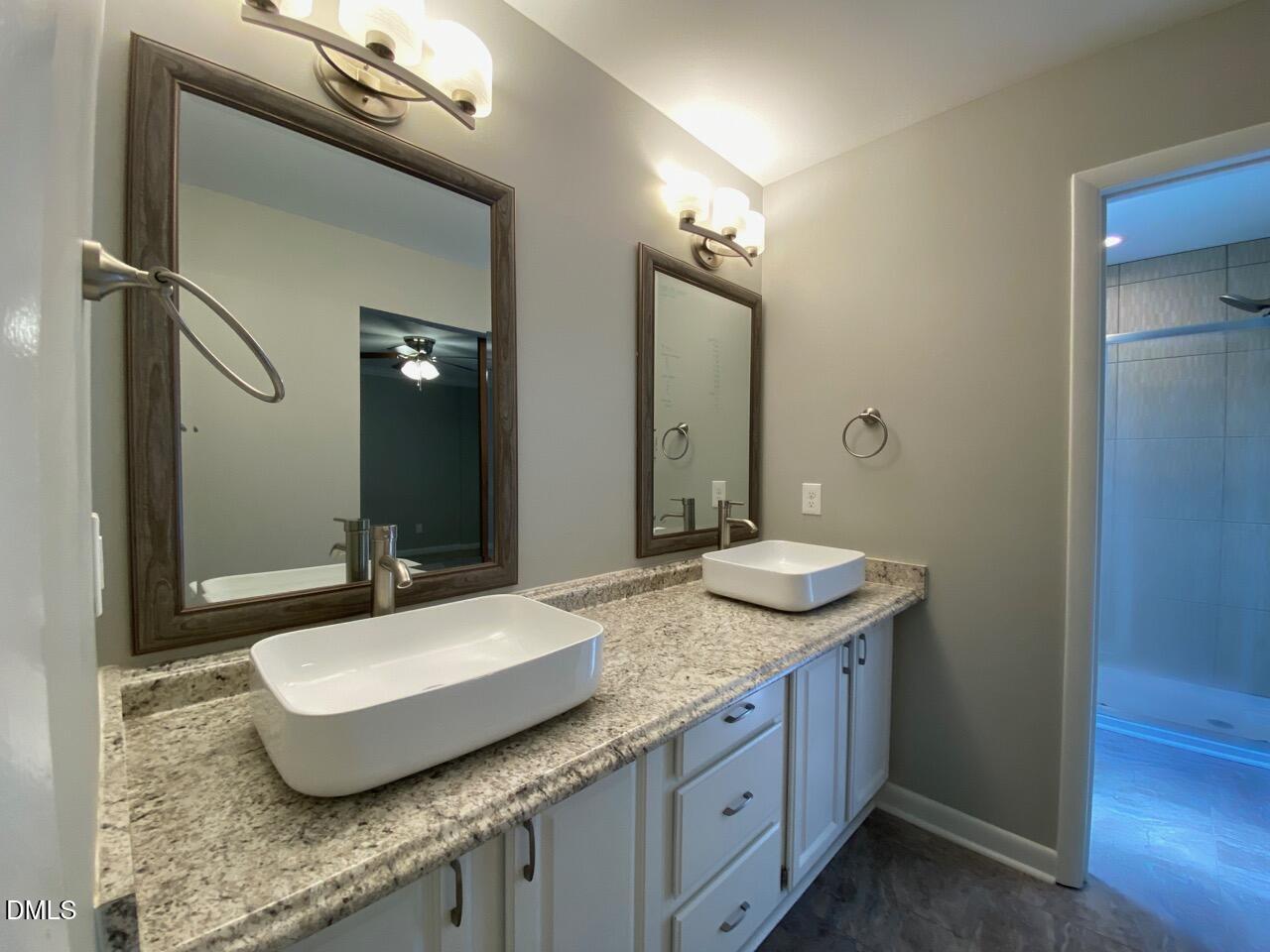 2910 Haven Road Raleigh, NC 27610 - Photo 22 of 26 a bathroom with a granite countertop sink and a mirror