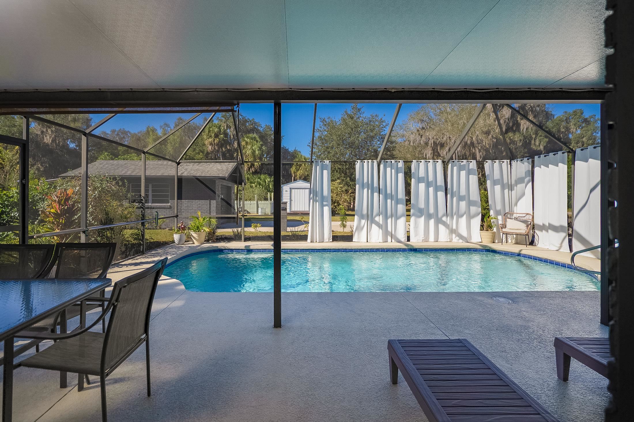 123 Esperanza Grove Road East Palatka, FL 32131 - Photo 17 of 59 View of pool with glass enclosure, a sunroom, a storage shed, and a patio
