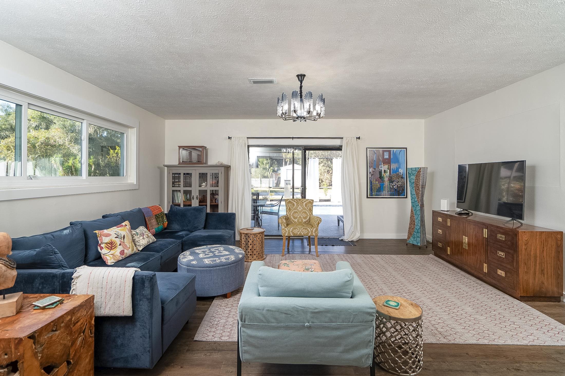 123 Esperanza Grove Road East Palatka, FL 32131 - Photo 9 of 59 Living room featuring wood finished floors, a textured ceiling, and a chandelier