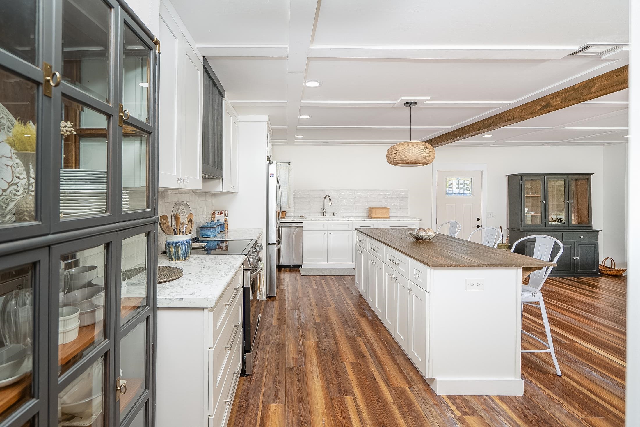 123 Esperanza Grove Road East Palatka, FL 32131 - Photo 10 of 59 Kitchen featuring a kitchen breakfast bar, beam ceiling, white cabinetry, decorative backsplash, and dark wood-style flooring