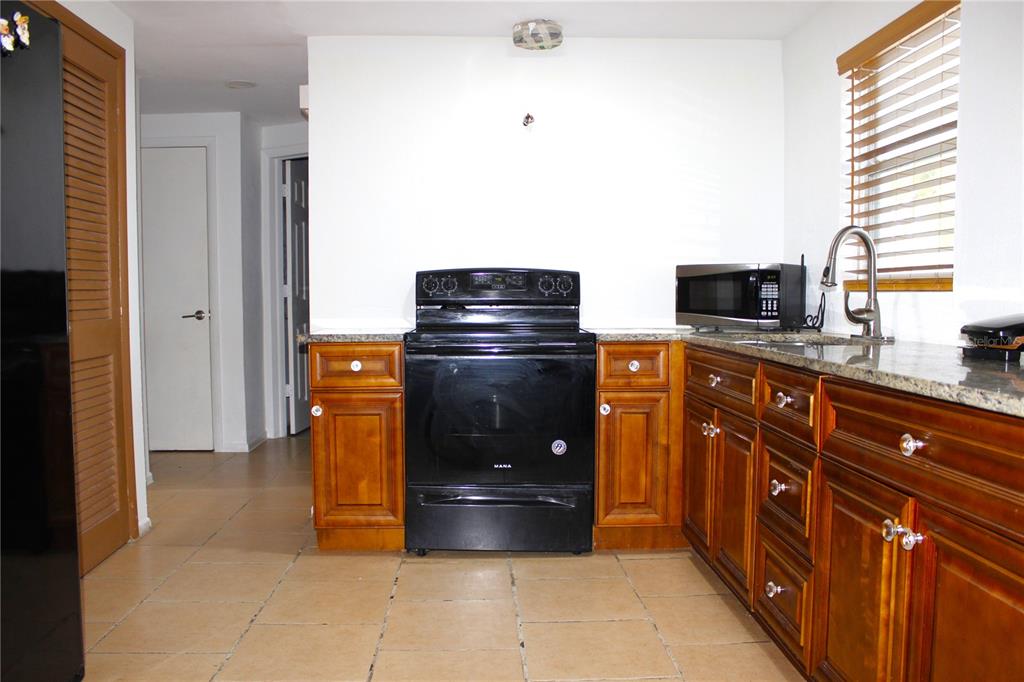 3542 Connon Drive New Port Richey, FL 34652 - Photo 32 of 47 a kitchen with stainless steel appliances granite countertop a stove and a refrigerator