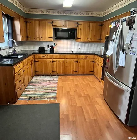 a kitchen with stainless steel appliances granite countertop a sink a stove and a refrigerator